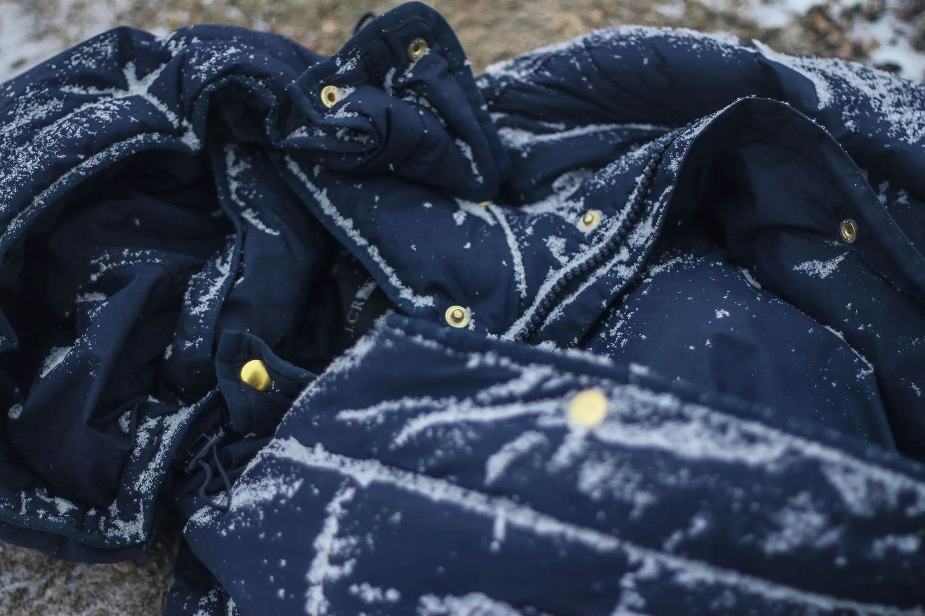 Dunkelblaue Isolationsjacke mit deutlich sichtbaren Steppkammern, mit Schnee bedeckt